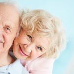 Happy and affectionate elderly couple looking at camera