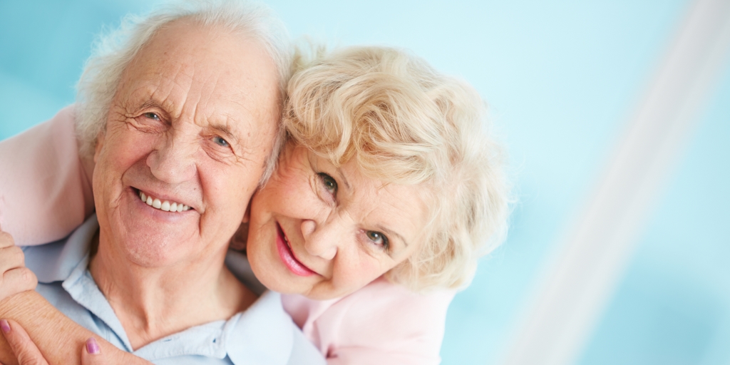 Happy and affectionate elderly couple looking at camera